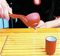 Using the tongs to empty the cups. - Copyright – Stock Photo / Register Mark