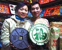 Yunnan couple displaying bricked pu cha (shu style) in tea shop. - Copyright – Stock Photo / Register Mark