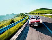 A man and woman cruising along a scenic road in their convertible. - Copyright – Stock Photo / Register Mark