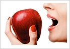 Woman taking a bite out of a red apple. - Copyright – Stock Photo / Register Mark